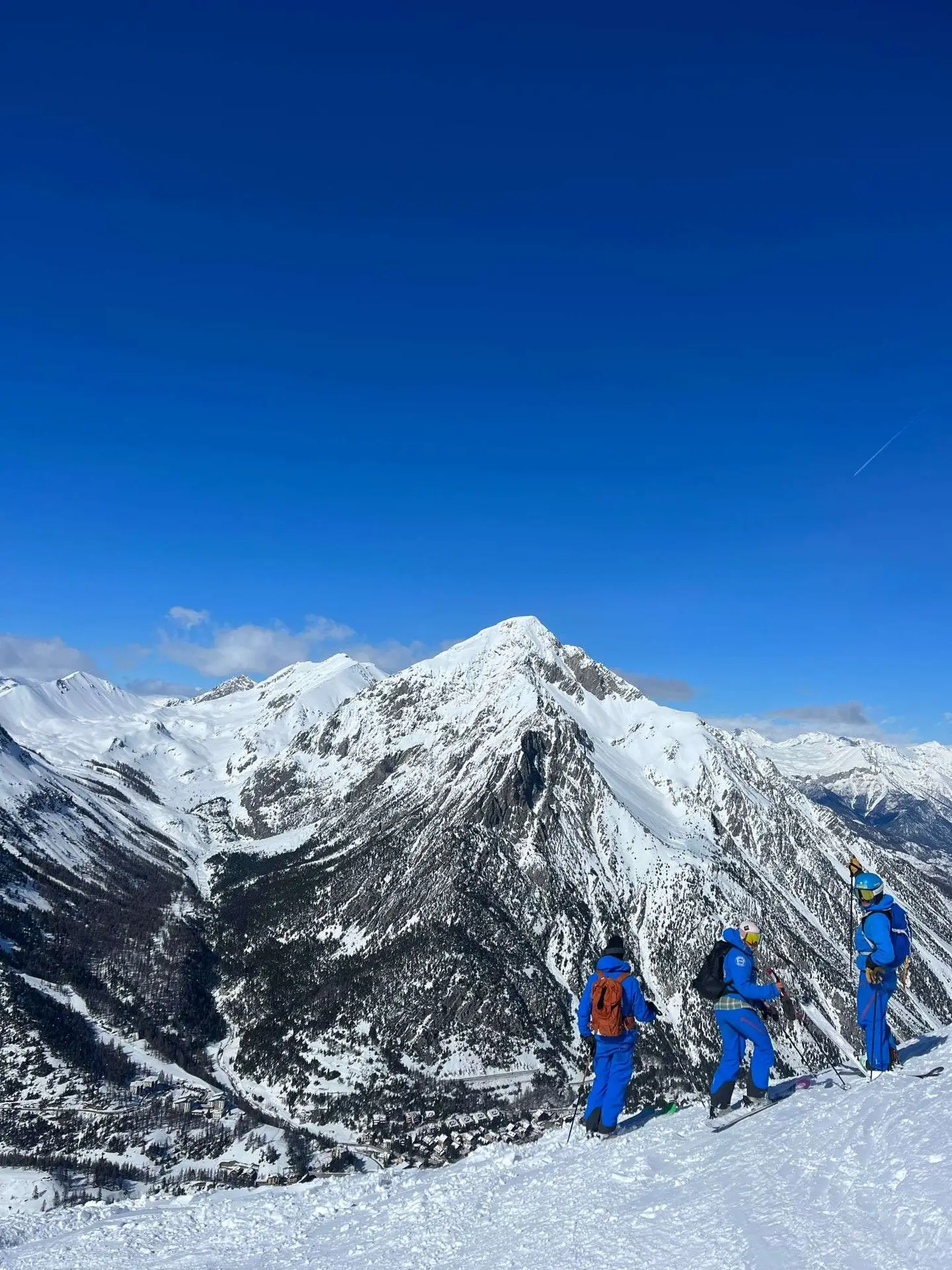 Moniteur guidant un petit groupe dans la neige poudreuse, en montagne